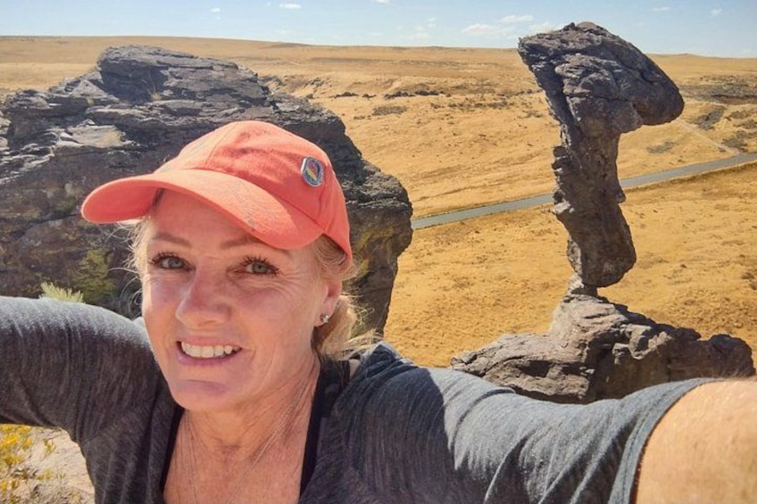 A person taking a selfie with a rock formation in the background. 1