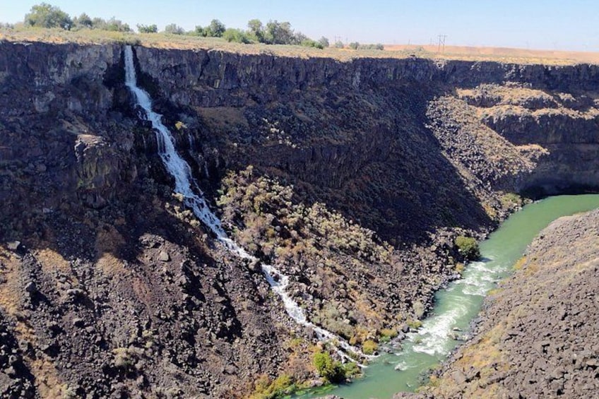 A waterfall cascading down a rocky cliff into a river. 4