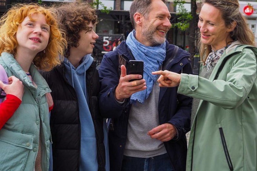 A group of people standing outdoors, one person holding a smartphone. 5