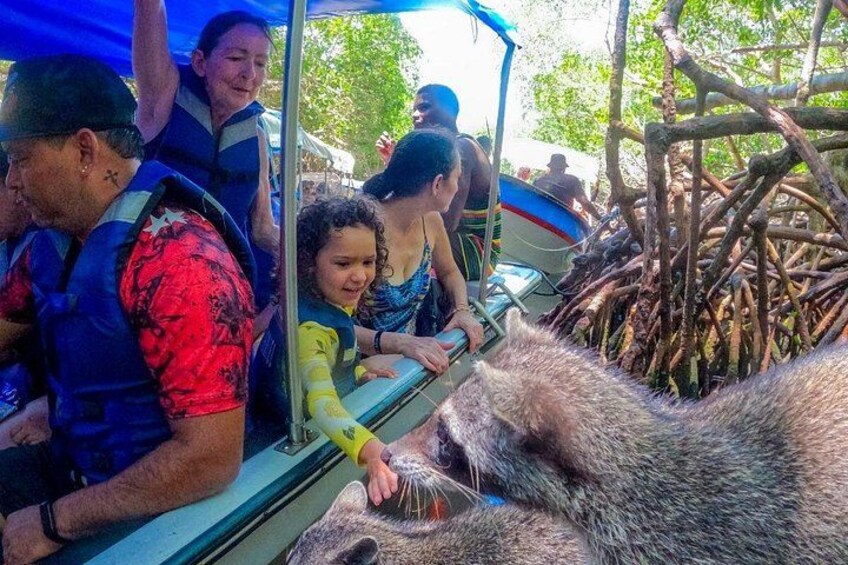 Un grupo de personas en un bote interactuando con una nutria grande. 3