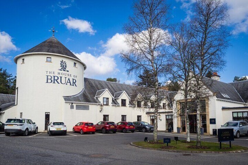 The House of Bruar, a white building with a round tower, parked cars, and trees in front. 5