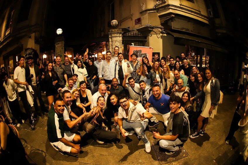 A group of people posing for a photo in an urban setting with historical architecture. 5