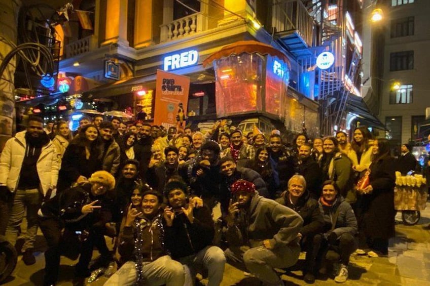 A group of people gathered on a city street at night. 1