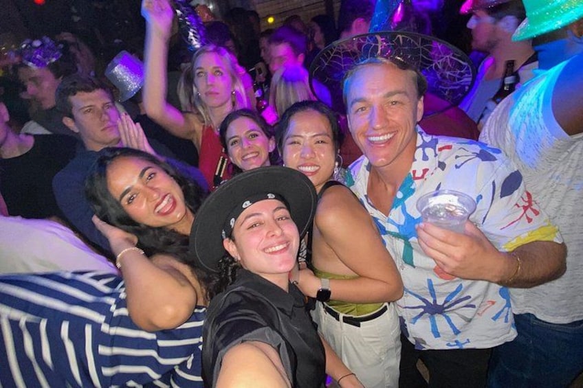 A group of people at a party with drinks and a festive atmosphere. 2