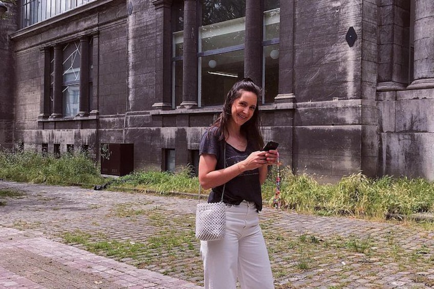 Una persona de pie sobre un camino empedrado frente a un edificio de piedra con columnas. 5