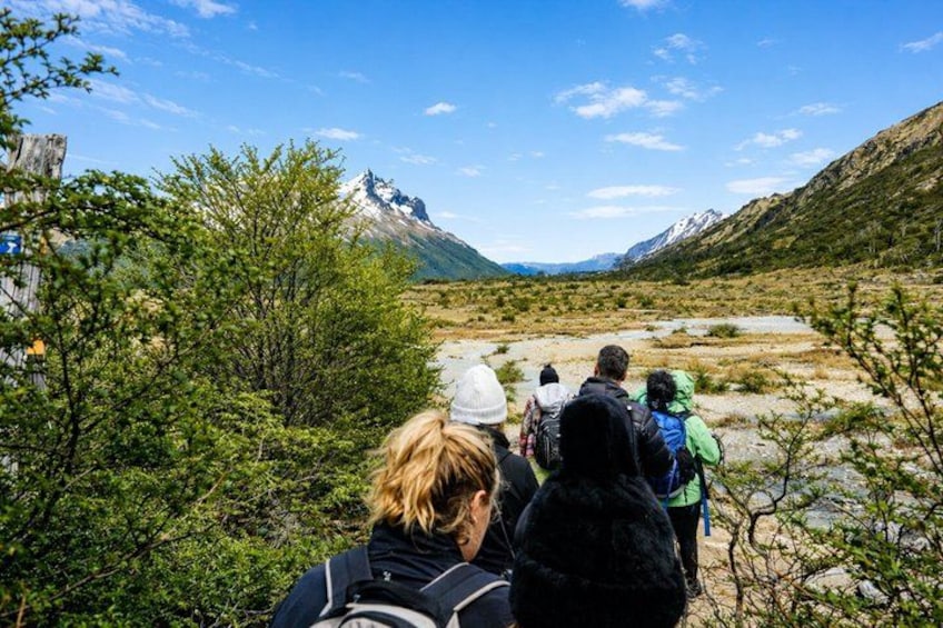 Un groupe de randonneurs sur un sentier, avec des montagnes en arrière-plan. 3