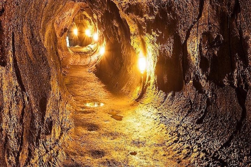 Un tunnel con pareti irregolari e un sentiero stretto. 1