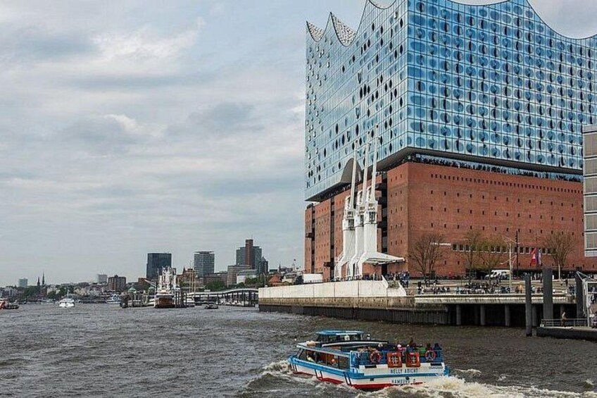 Een rivier met een bootje, een modern gebouw met een uniek ontwerp en een stadsachtergrond. 5
