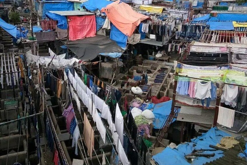 Ein dicht besuchter Markt mit zahlreichen Ständen und hängender Kleidung. 2