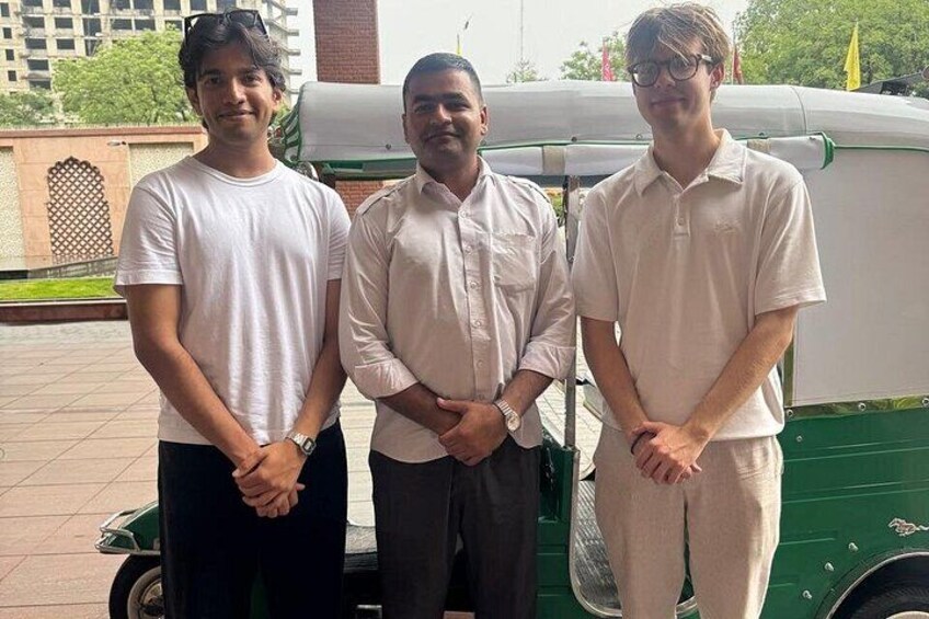 Three men standing in front of a green vehicle. 2
