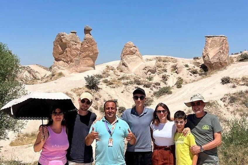 A group of people standing in a desert landscape with rock formations. 2