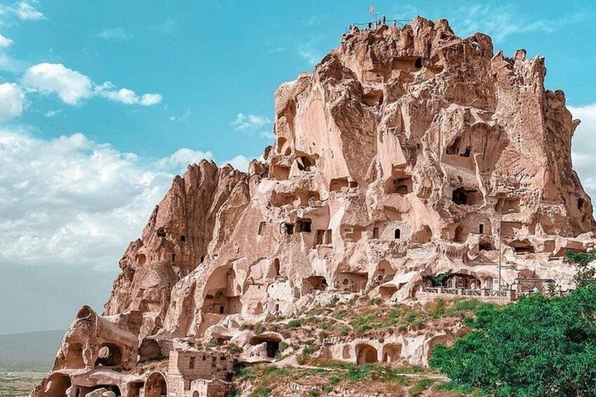 A rock formation with multiple cave dwellings and a clear sky. 4