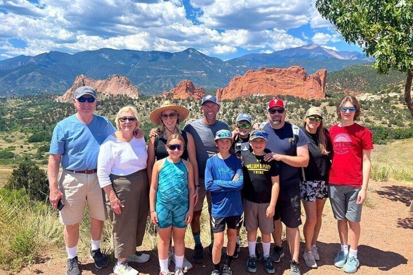 A group of people standing on a trail with a mountainous landscape in the background. 5