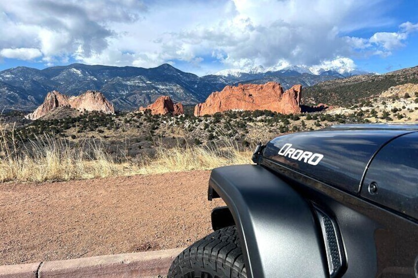 A vehicle with 'ORO' on the side, parked in a desert landscape with mountains in the background. 1