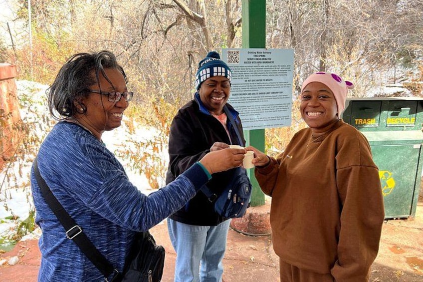 Three people outdoors with a trash bin and a sign in the background. 4