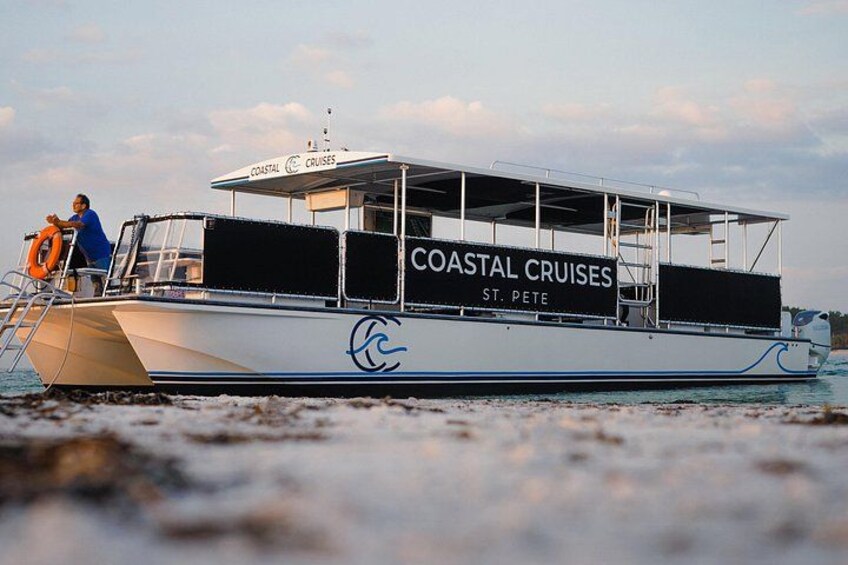 A boat named 'Coastal Cruises' with a person standing on the deck. 3