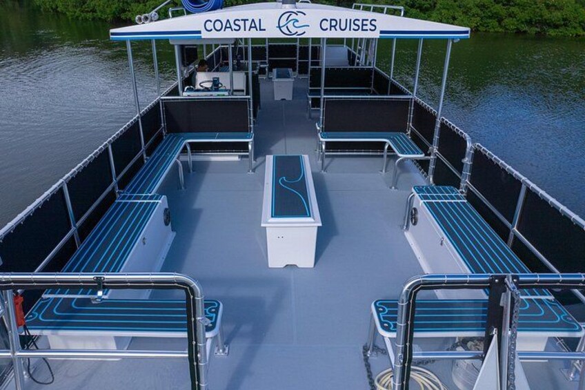 A boat with a covered deck, seating areas, and a railing. 2