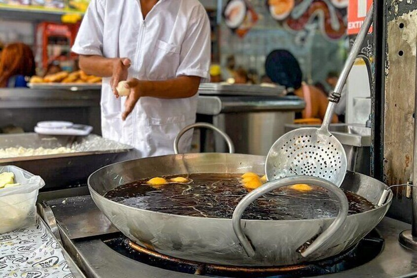 Un wok sur une cuisinière, avec de l’huile et des aliments en train de cuire. 3