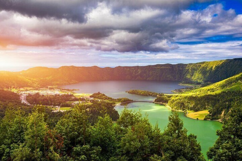 A mountainous landscape with a lake surrounded by dense forest. 1
