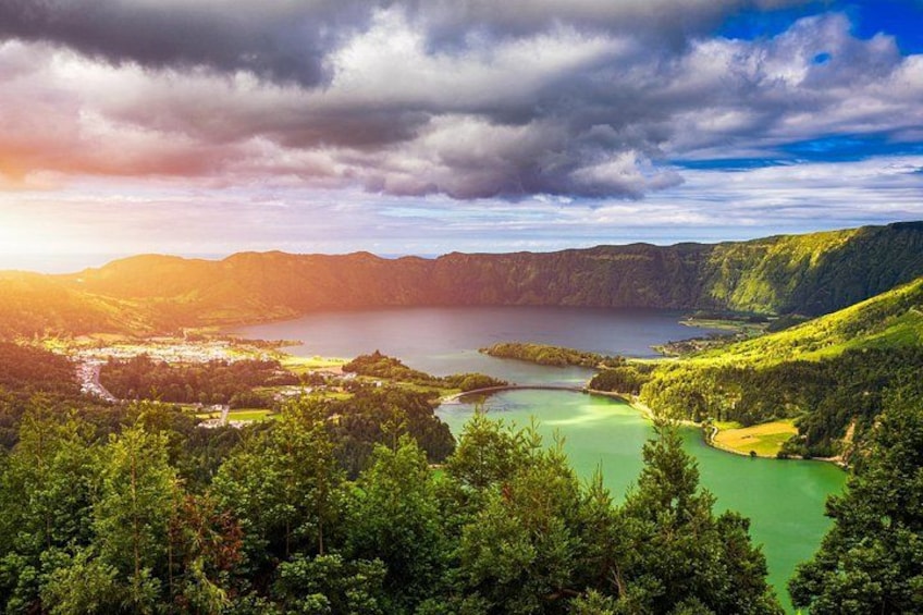 A mountainous landscape with a lake, forested areas, and a clear sky. 3