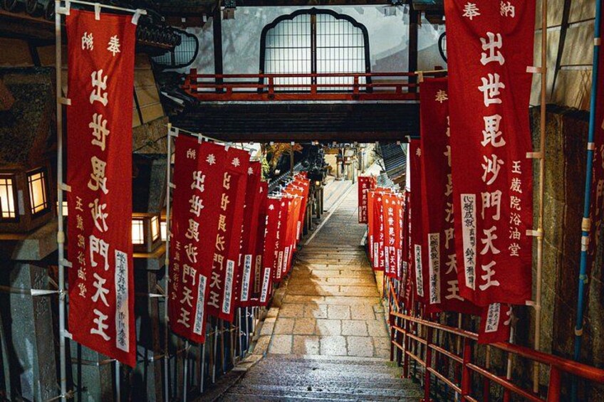 En gang med røde bannere hængende langs begge sider, der fører til en traditionel japansk port. 4