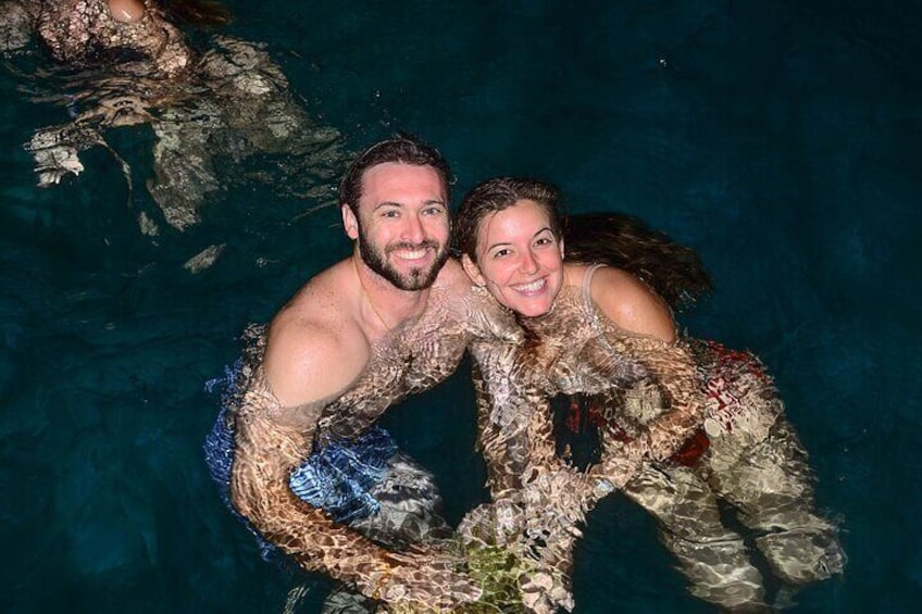 Twee personen in een zwembad met een rotsachtig onderwaterlandschap. 1