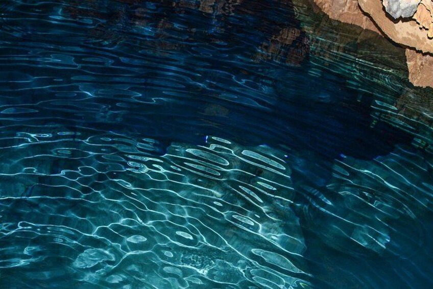 Agua azul cristalina con ondas y reflejos de las rocas circundantes. 5