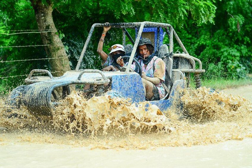 Un vehículo avanza por una zona inundada, con agua salpicando a su alrededor. 3