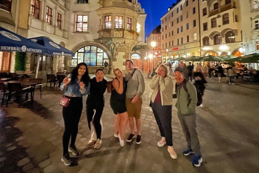 A group of people standing in a square with historic buildings in the background. 5
