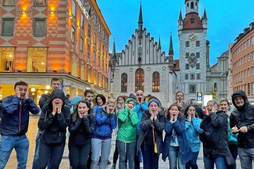 A group of people in front of a historic building with a clock tower. 4