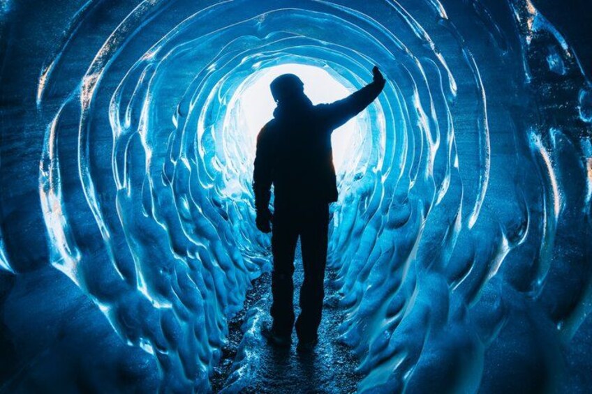 Una persona de pie en un túnel iluminado con un resplandor azul. 4
