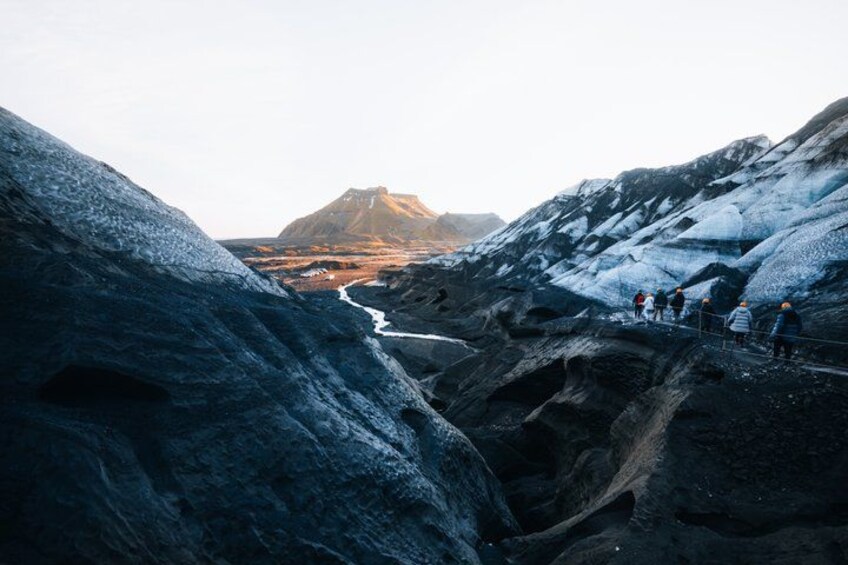 Un glaciar con un grupo de personas sobre un promontorio. 3