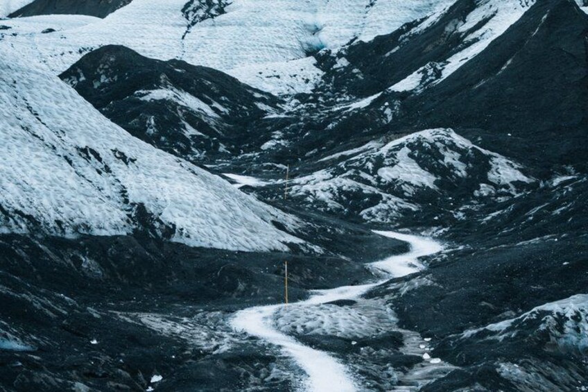 Un paisaje montañoso cubierto de nieve con un camino serpenteante. 2