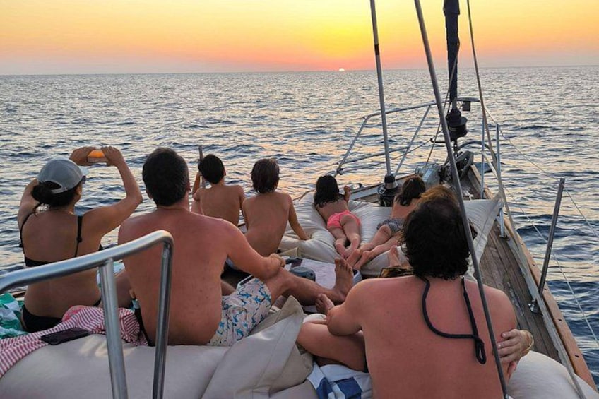 Un grupo de personas en un barco al atardecer. 3