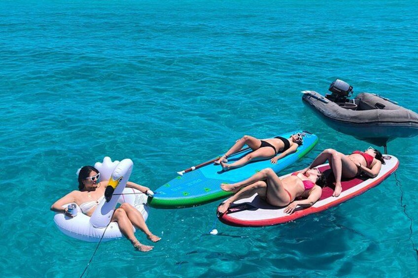 Tres personas en balsas inflables en aguas azules cristalinas. 5