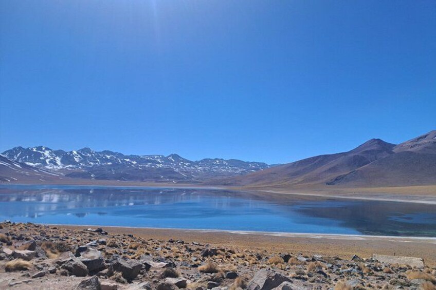 Un lago circondato da montagne, con cielo sereno. 5