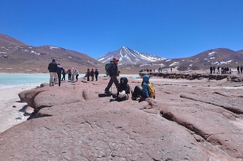 Un gruppo di persone che fanno trekking su un terreno roccioso, con una montagna sullo sfondo. 3