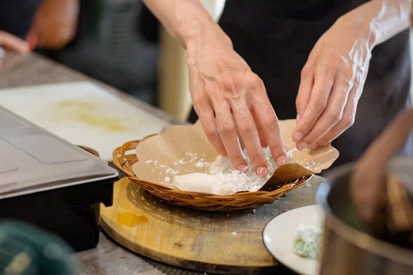 Hands placing a flatbread on a wooden board. 4
