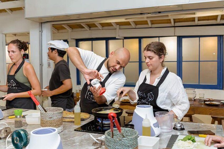 A group of people cooking in a kitchen. 1