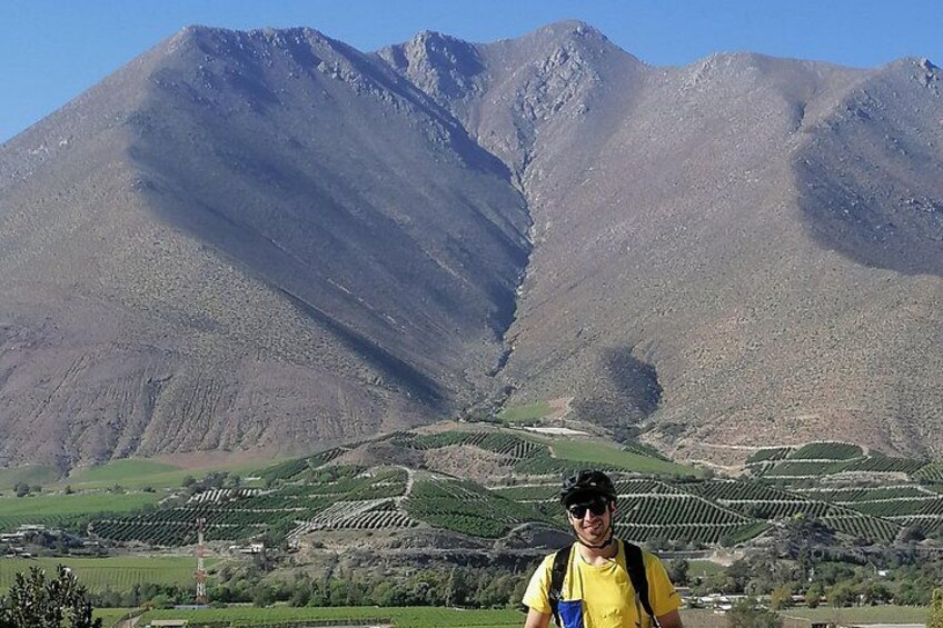 A mountainous landscape with terraced fields and a person standing in the foreground. 1