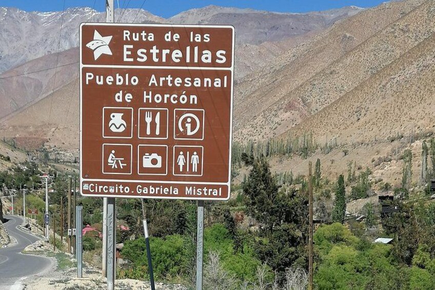 A signboard with symbols for amenities and a mountainous landscape in the background. 3