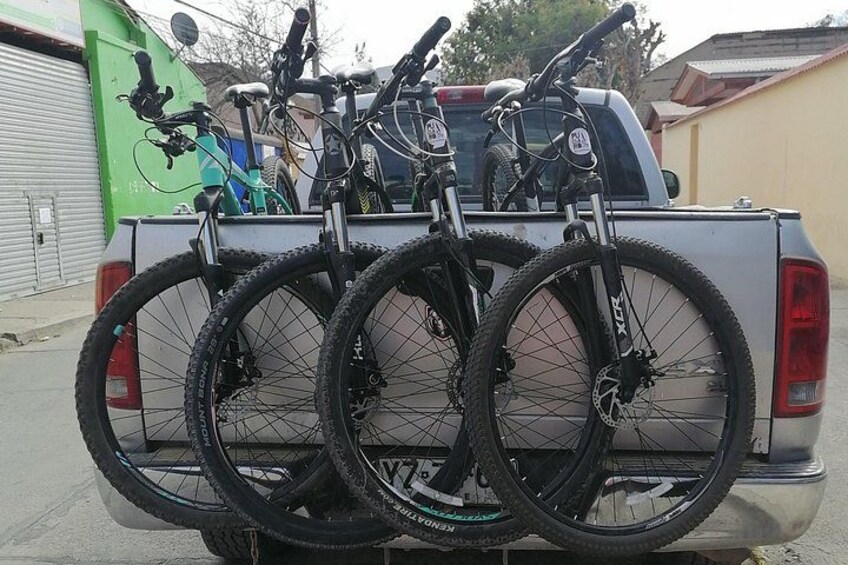 A white pickup truck with a bike rack loaded with three bicycles. 5