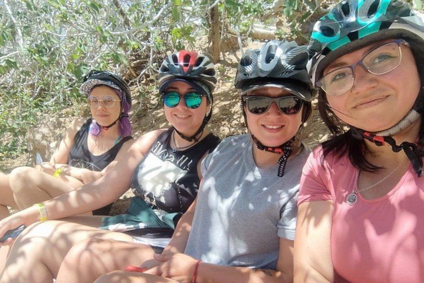 Three people wearing helmets and cycling attire, sitting outdoors. 4