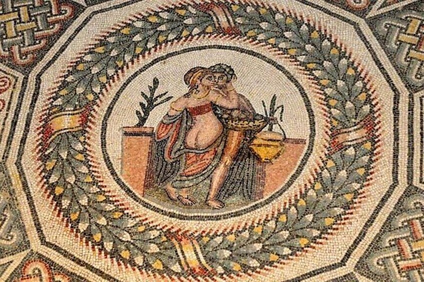 A mosaic with a central figure surrounded by a geometric border. 2