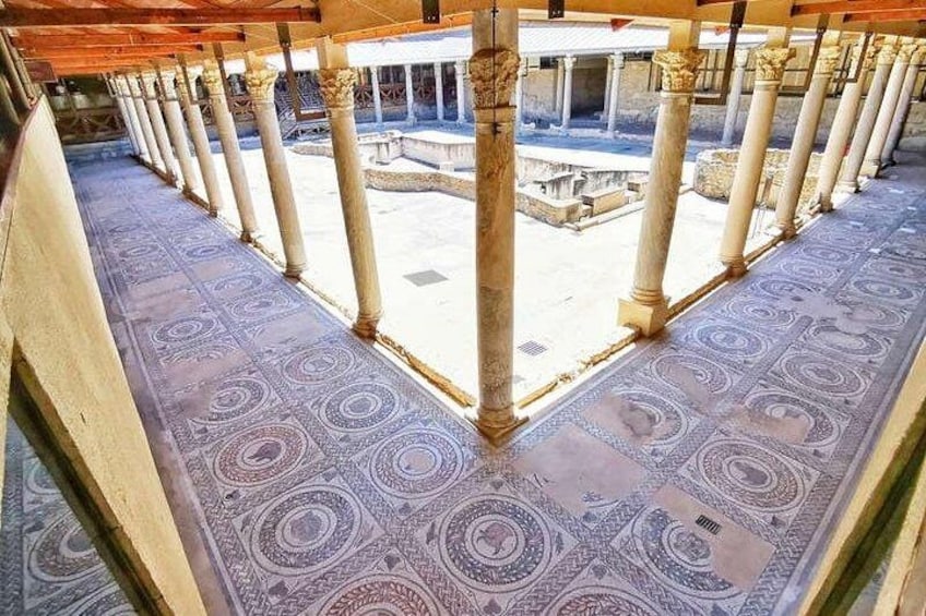 A colonnade with patterned flooring and columns. 2
