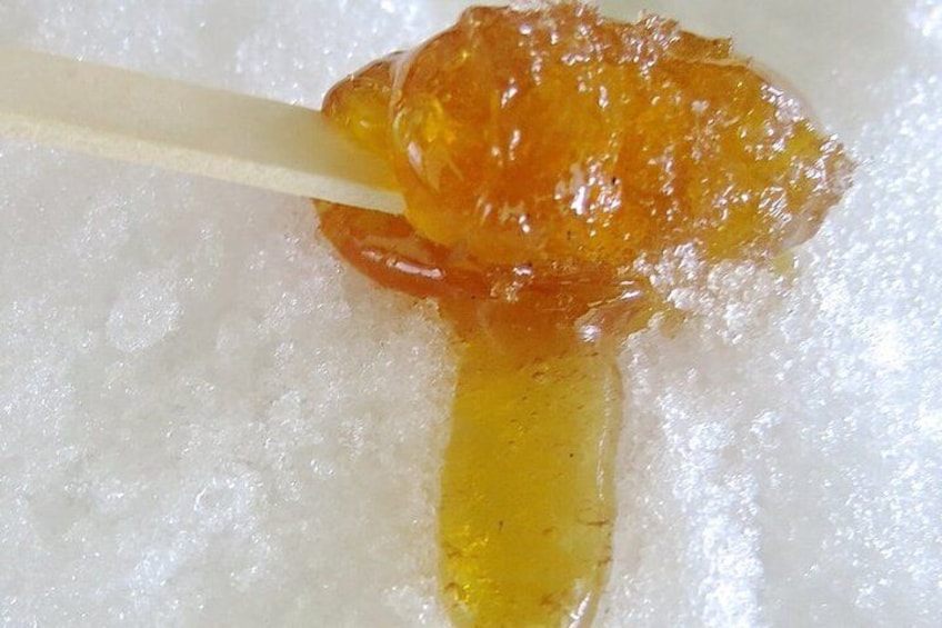 A piece of food on a white surface with a yellowish liquid. 2
