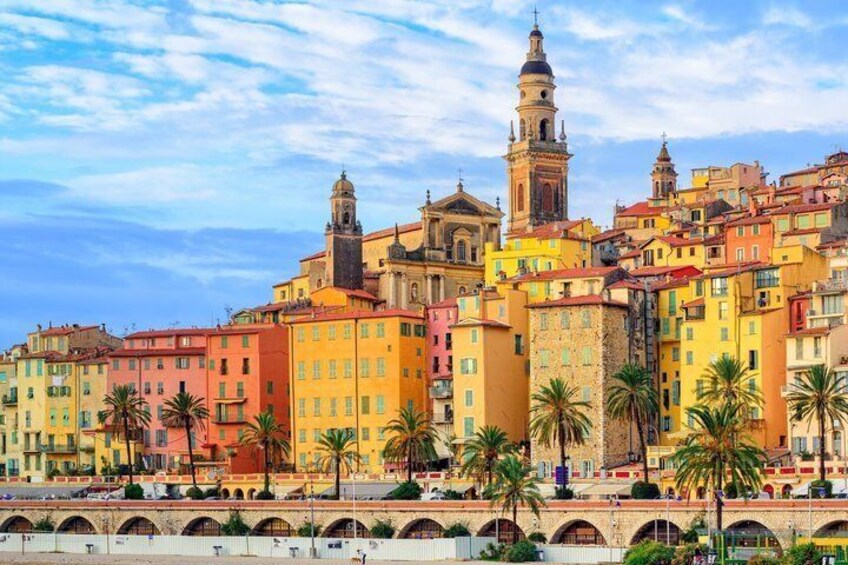 A colorful coastal cityscape with historic buildings and a prominent bell tower. 5