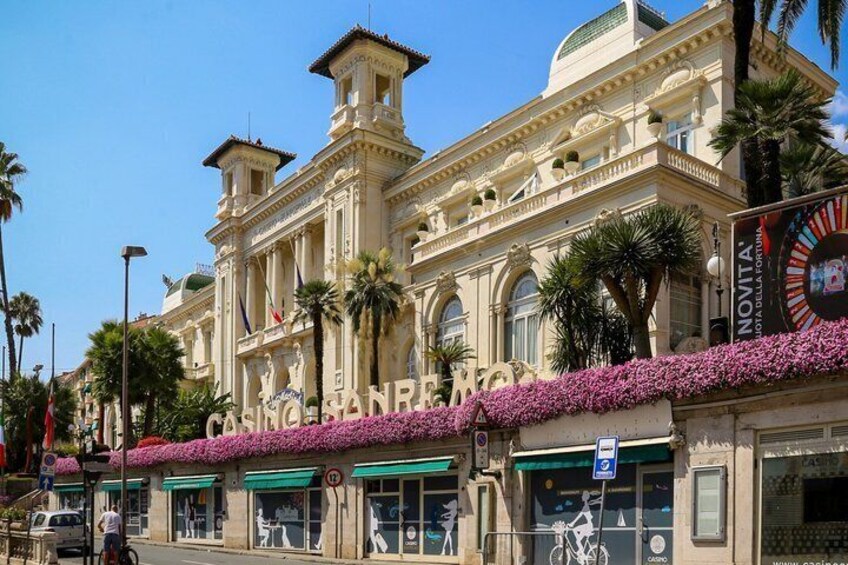 A historic building with ornate architecture, a casino sign, and a flower-adorned entrance. 2