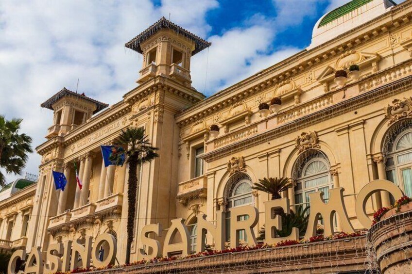 A historic building with ornate architecture, flags, and the text 'CASINO SA REINA' on its facade. 3