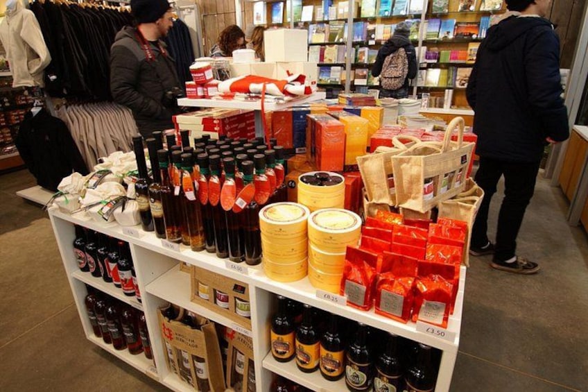 A store with shelves of bottles and boxes, a person browsing, and another person standing. 3
